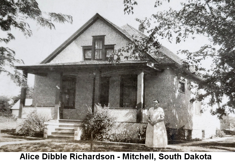 Black and white photo of Alice Dibble Richardson standing before a white stucco two-story arts & crafts-style home in Mitchell, South Dakota.